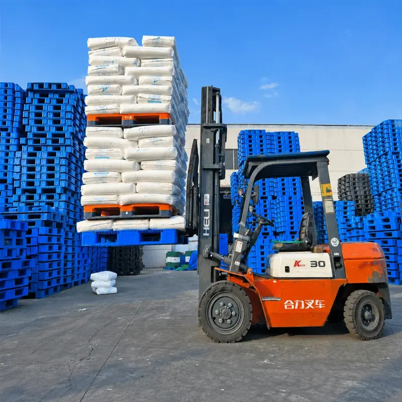 Xe nâng đang nâng pallet nhựa chở nhiều bao hàng nặng trong sân kho